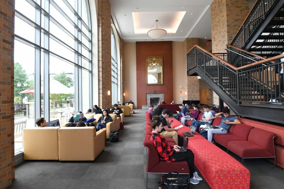 Estudantes descansando em um lounge iluminado do campus