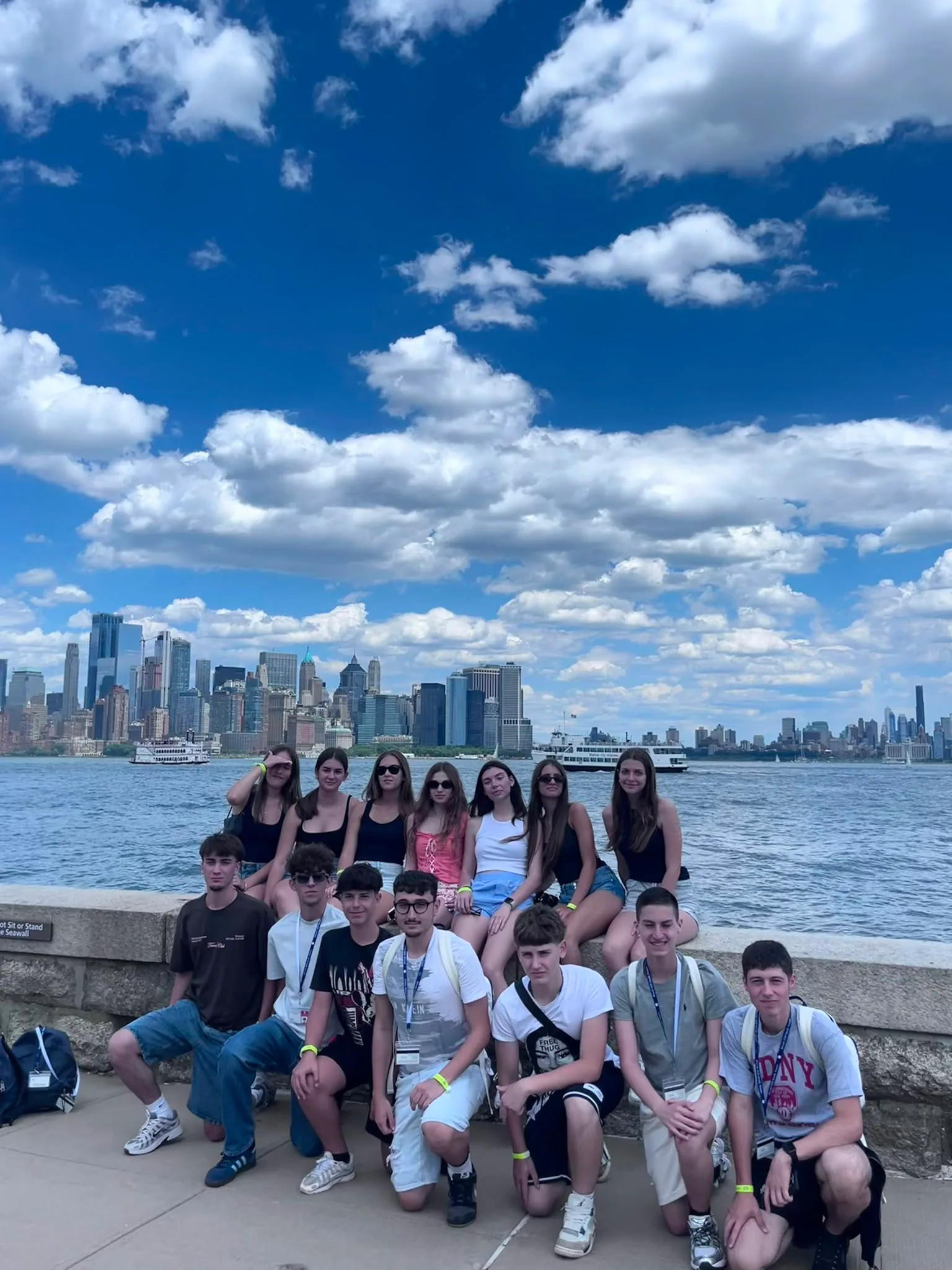 Students with the New York skyline across the water